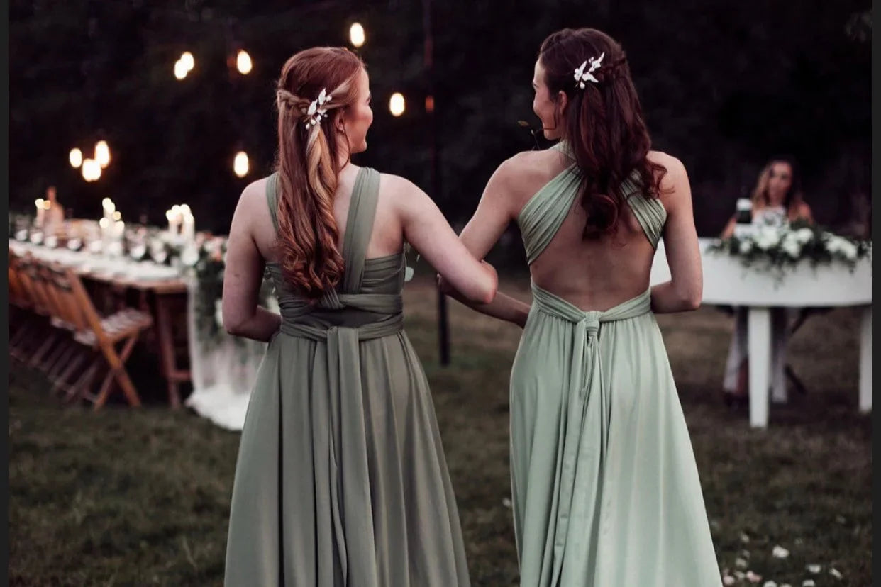 Two women in matching Eucalyptus Infinity Gown green bridesmaid dresses with open backs
