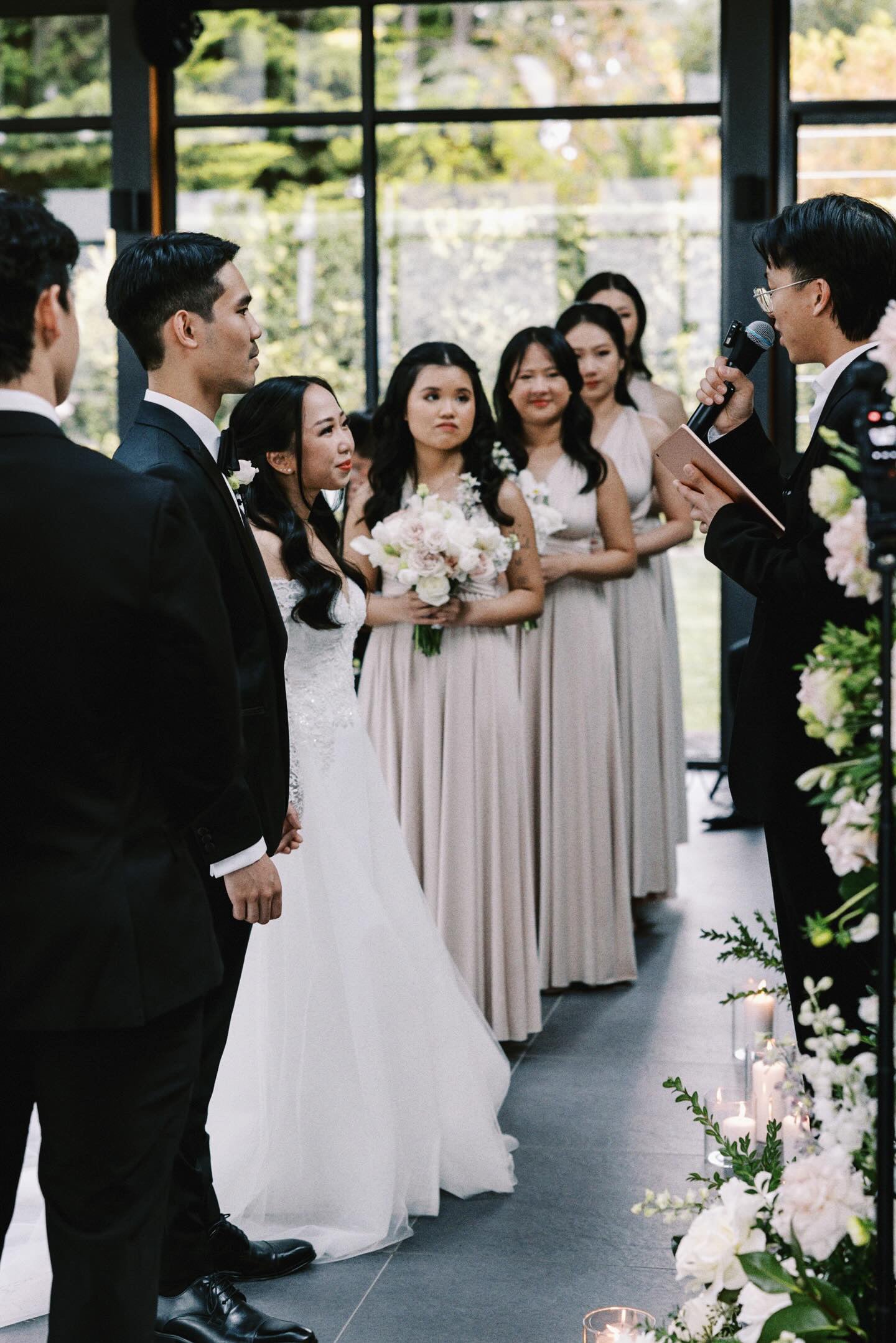 Bride in a white gown with wedding party wearing champagne bridesmaid gown during ceremony