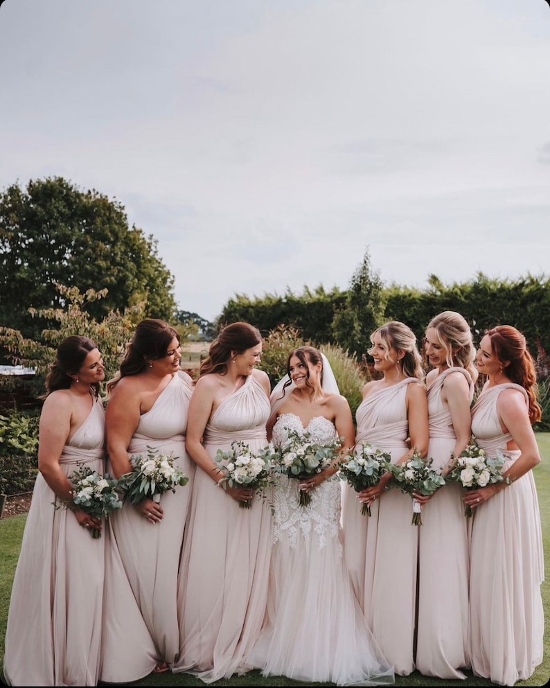 Seven women in formal Champagne Infinity Gowns holding bouquets, perfect multiway bridesmaid dress Australia