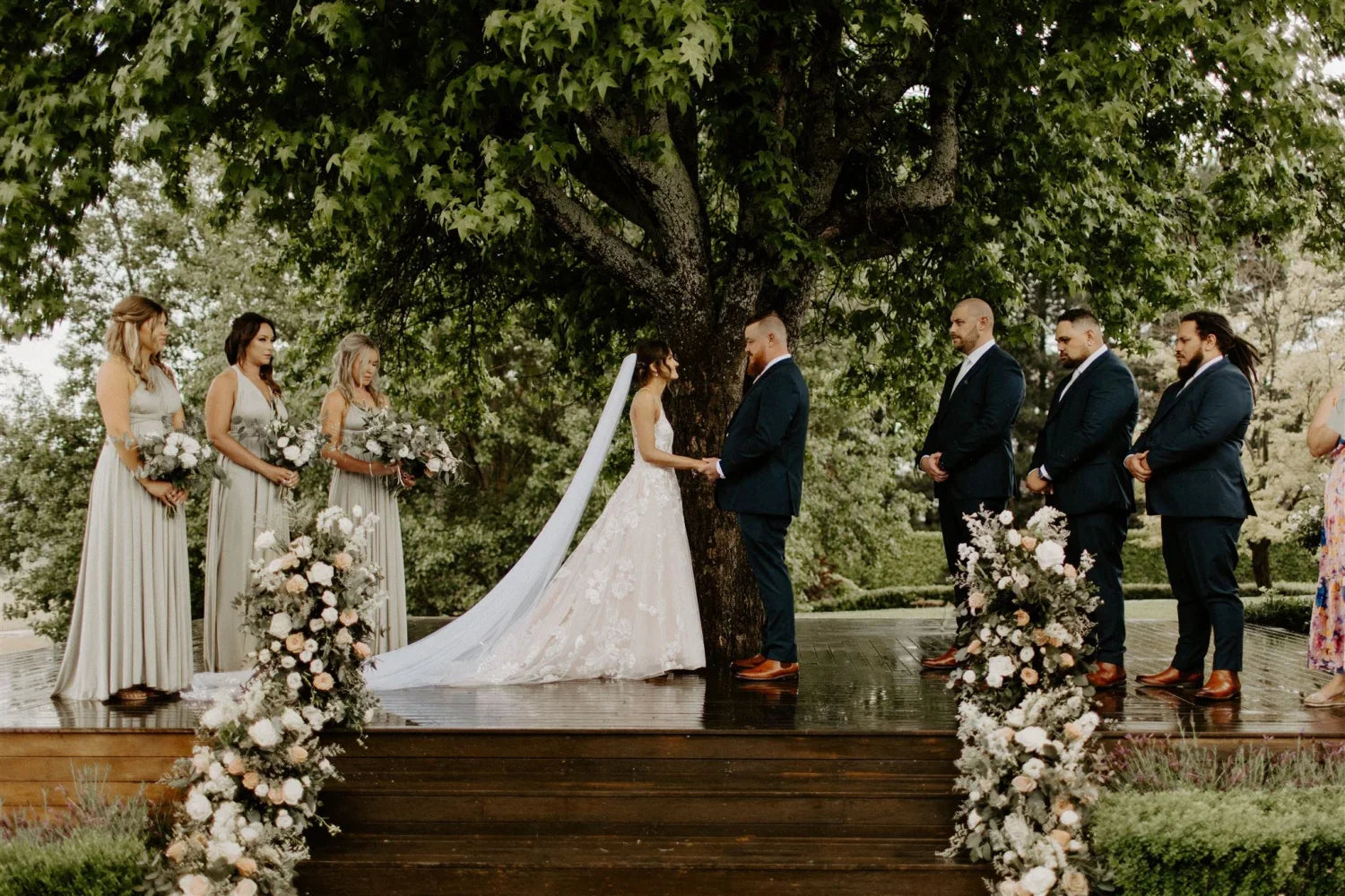 Bride and groom exchanging vows outdoors in an Eucalyptus Infinity Gown, a convertible green bridesmaid dress