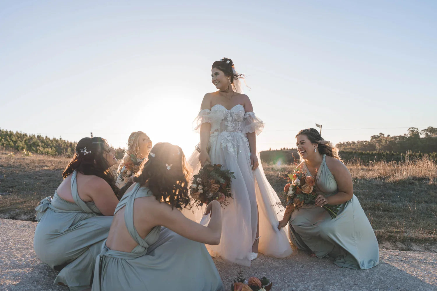 Bride in a white infinity gown with green bridesmaid dresses and bouquets