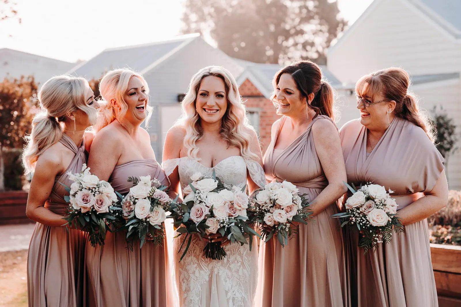 Women in formal attire holding bouquets wearing infinity dresses in Australia