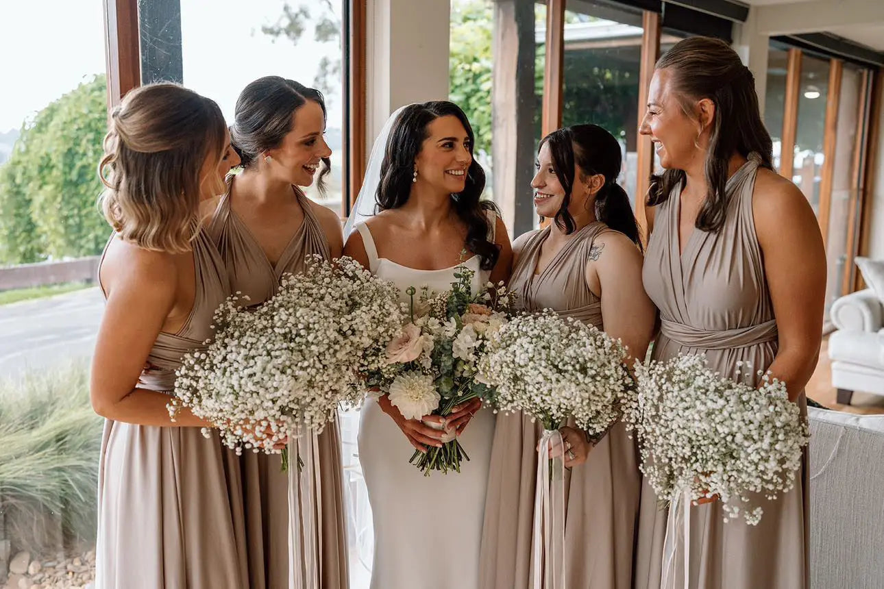 Bride in white gown with five taupe infinity bridesmaid dresses and bouquets at Bianca and Natham wedding