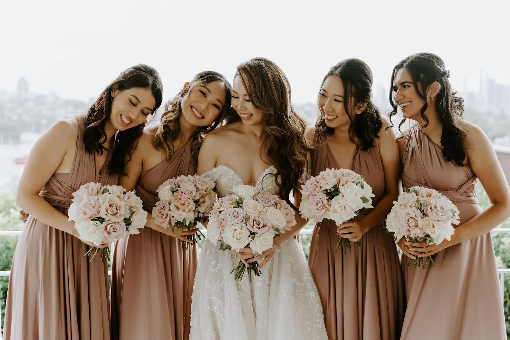 Bride and bridesmaids in infinity dresses holding bouquets at Holly and Paul wedding