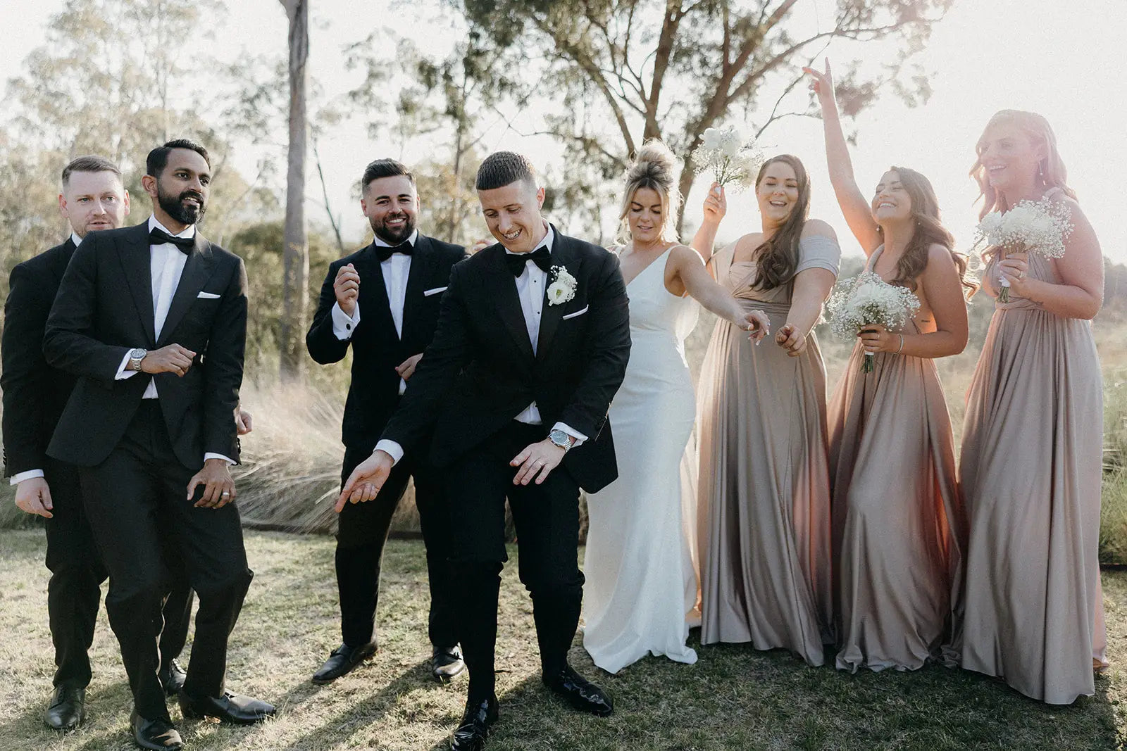 Joyous wedding party outdoors wearing stylish infinity dresses in Kate and Adam’s celebration