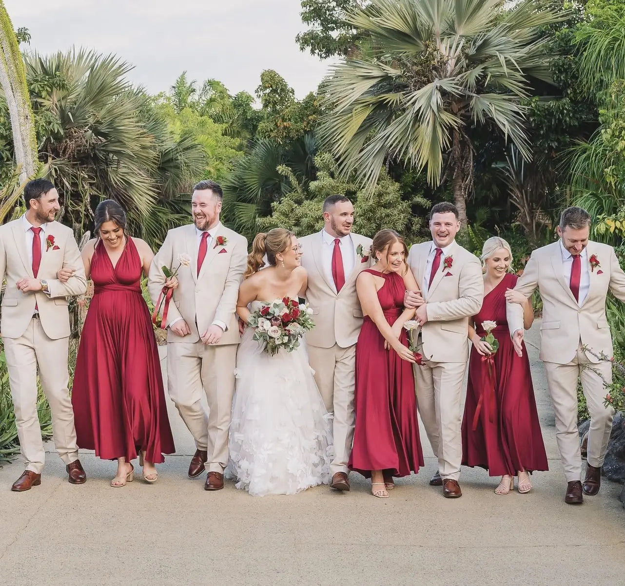 Wedding party in cream suits and red dresses featuring infinity bridesmaid dress in Australia