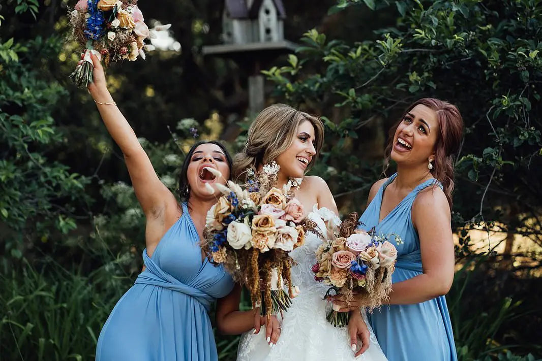 Three women in infinity dresses holding bouquets at Kyriaki and Yianni event in Australia