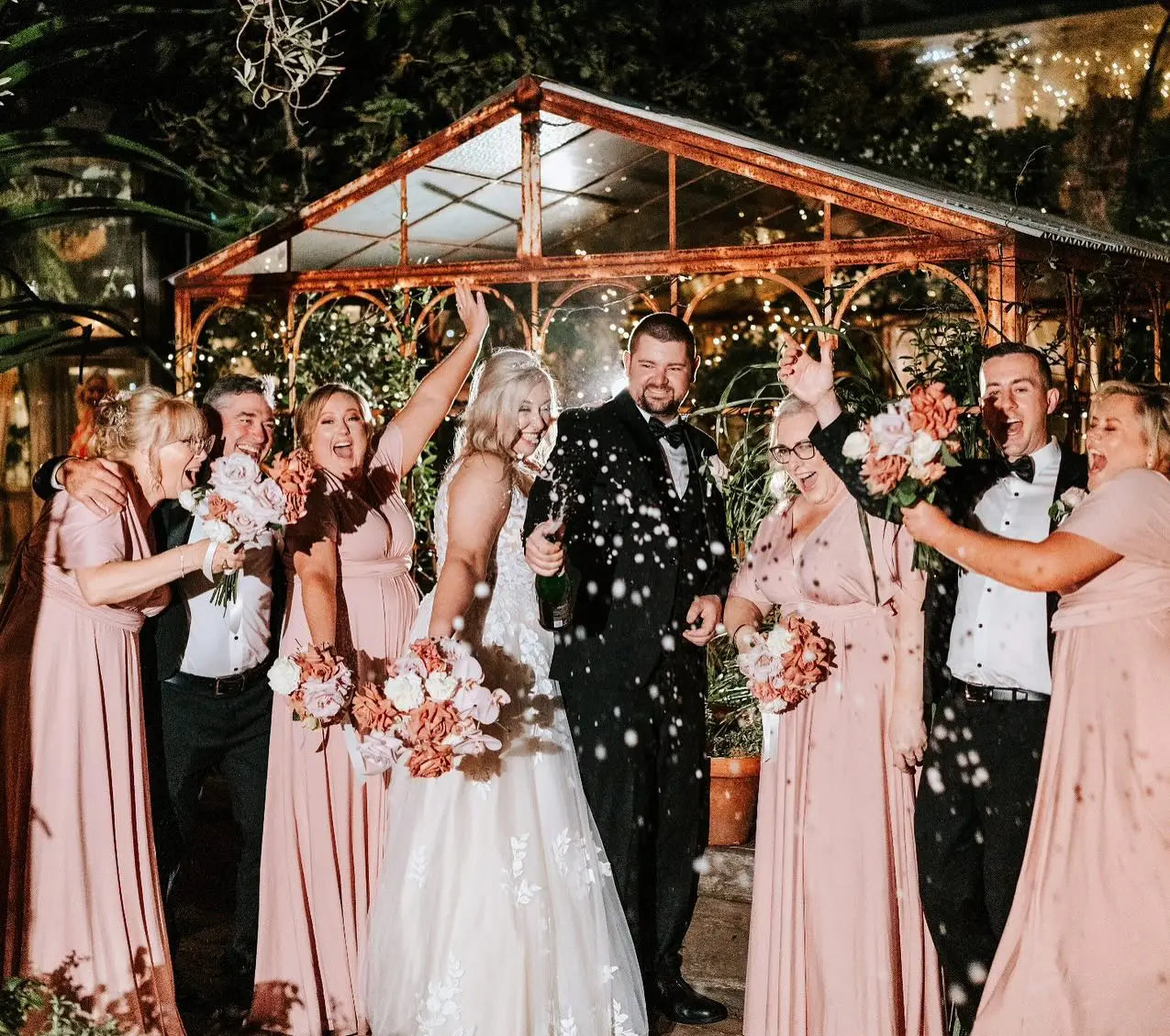 Joyful outdoor wedding celebration with wedding party and guests in infinity dresses Australia