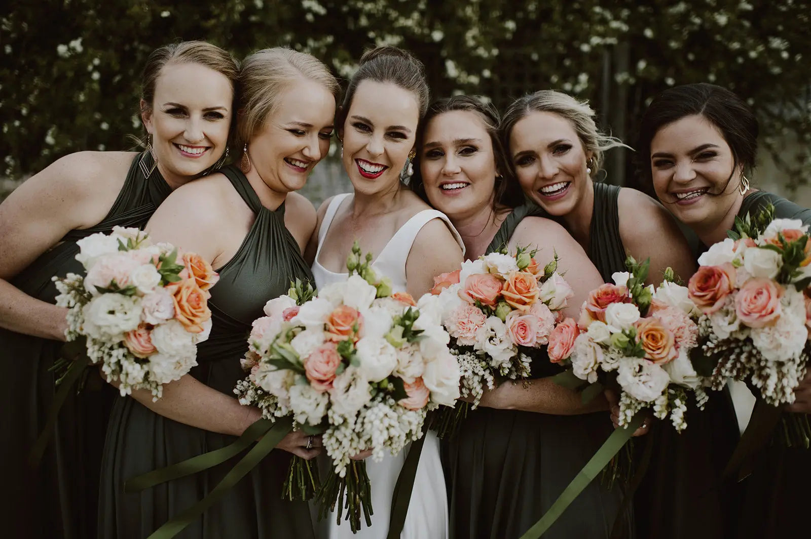 Six women in formal attire holding bouquets, showcasing infinity bridesmaid dresses in Australia