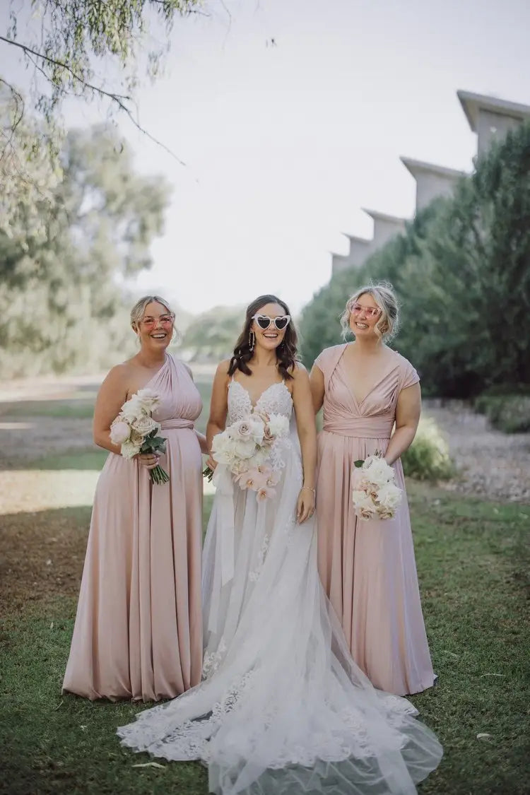 Three women in formal infinity dresses holding bouquets for Melissa and Manu wedding