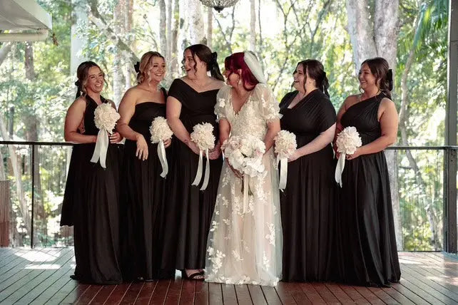 Six women in formal attire including infinity bridesmaid dress and wedding gown in Merinda and Ethan article