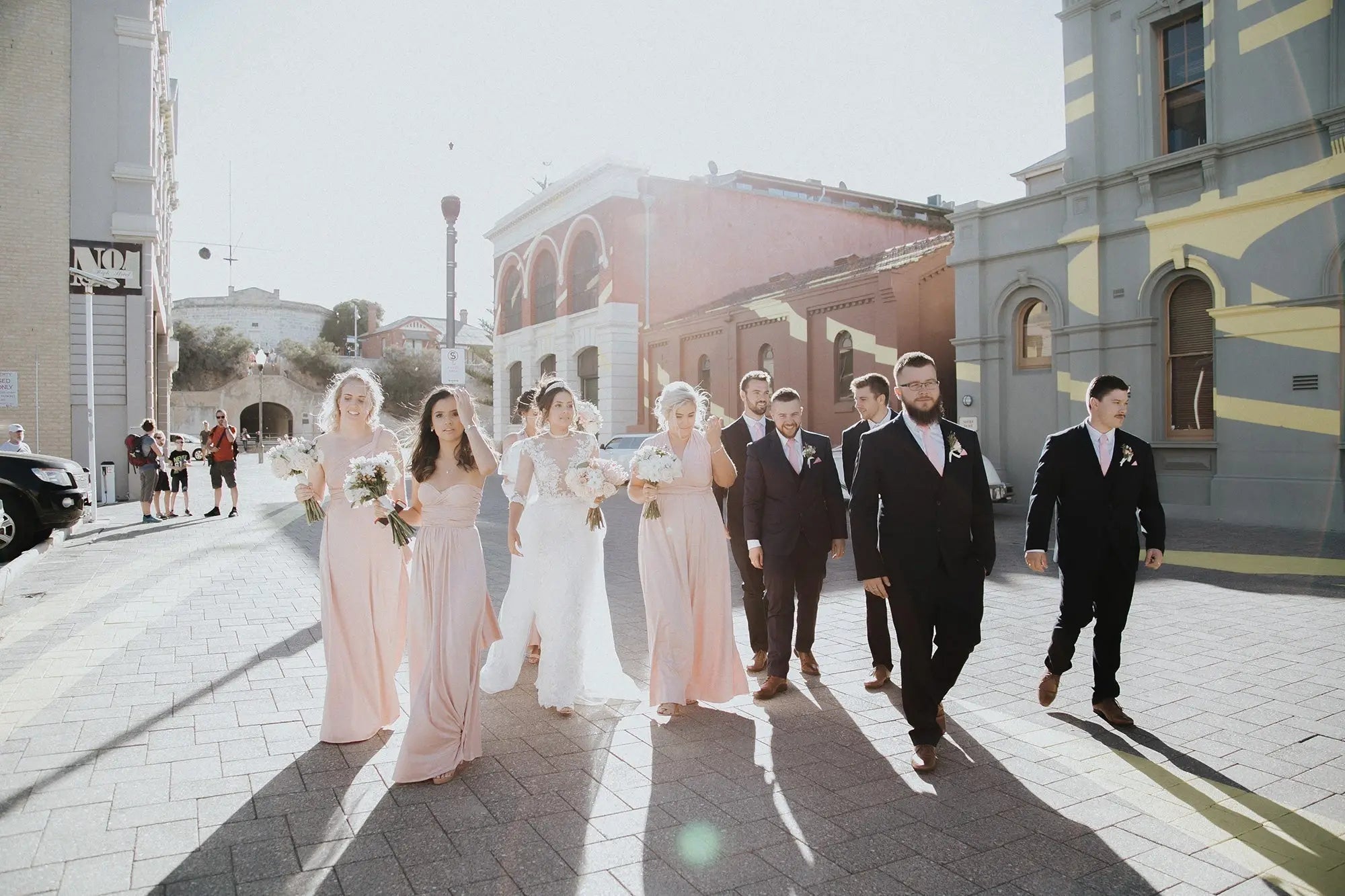 Wedding party walking outdoors in formal attire with infinity dresses in Rebecca and Blake article