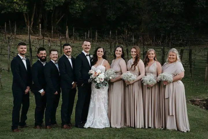 Bridal party in elegant infinity dresses posing for a group photo at Sally and Jordan wedding