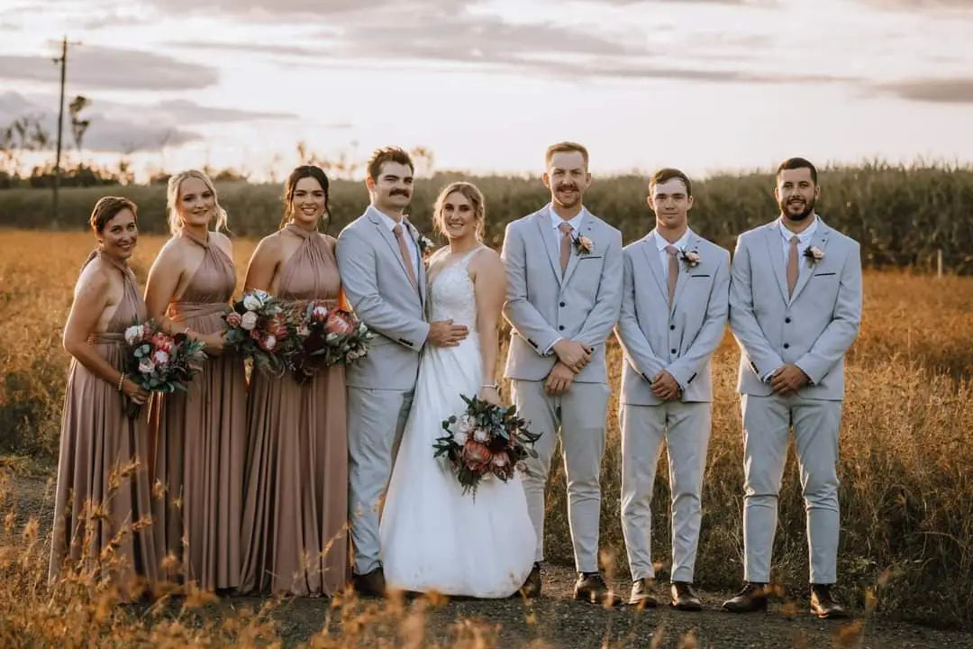Wedding party in a field at sunset wearing stylish infinity bridesmaid dresses in Australia