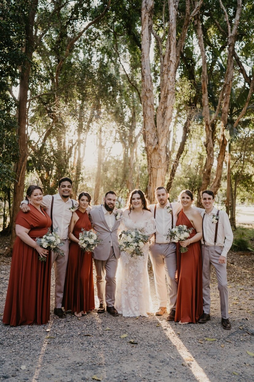 Wedding party in formal attire wearing Copper Infinity Gown, a versatile convertible dress