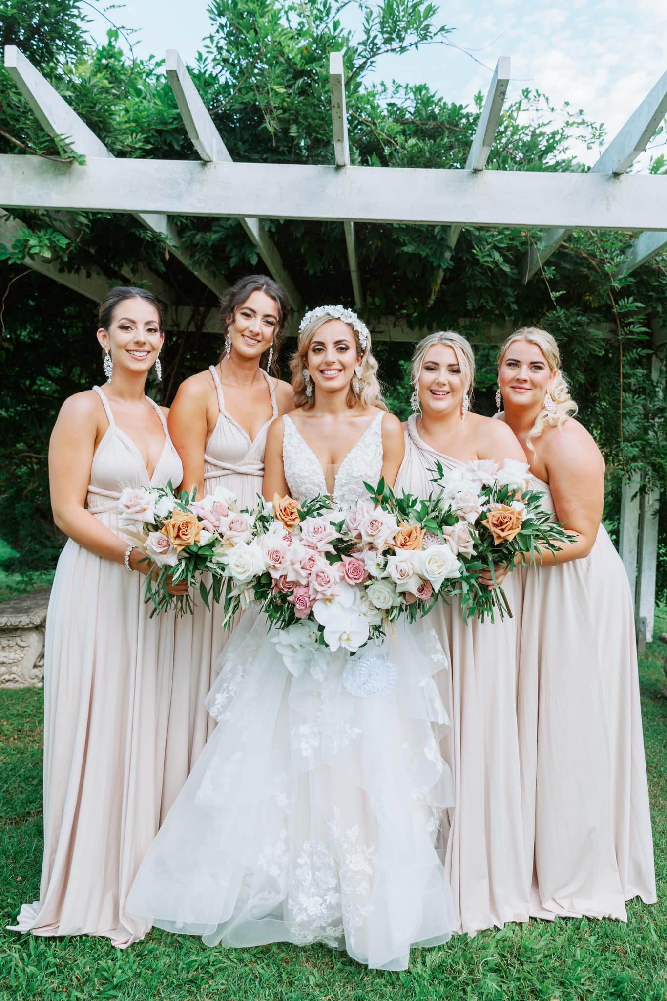 Bride in white gown with four bridesmaids in champagne bridesmaid gown, showcasing convertible dress Australia