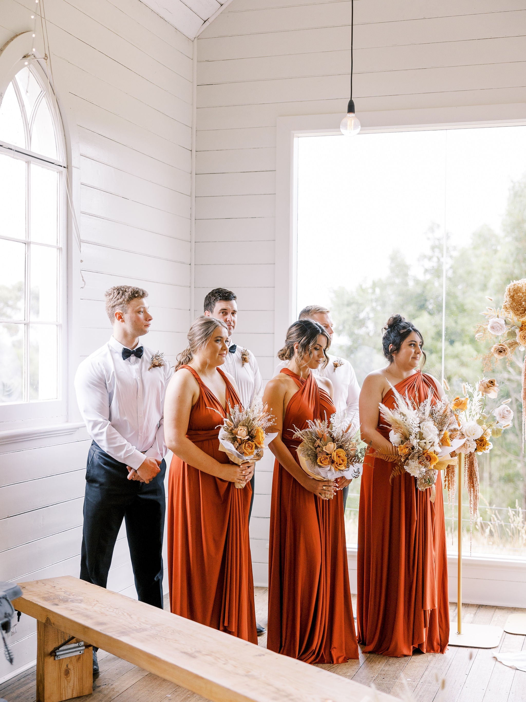Wedding party with bridesmaids in rust-colored multiway bridesmaid infinity gowns and groomsmen