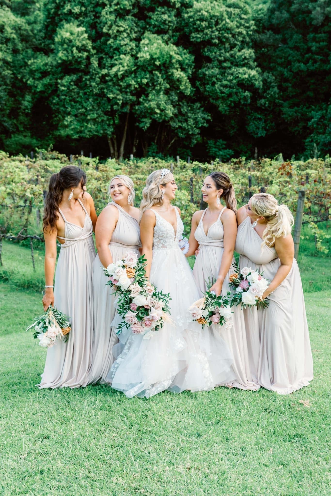 Bride in white Champagne Infinity Gown with five light beige multiway bridesmaid dresses