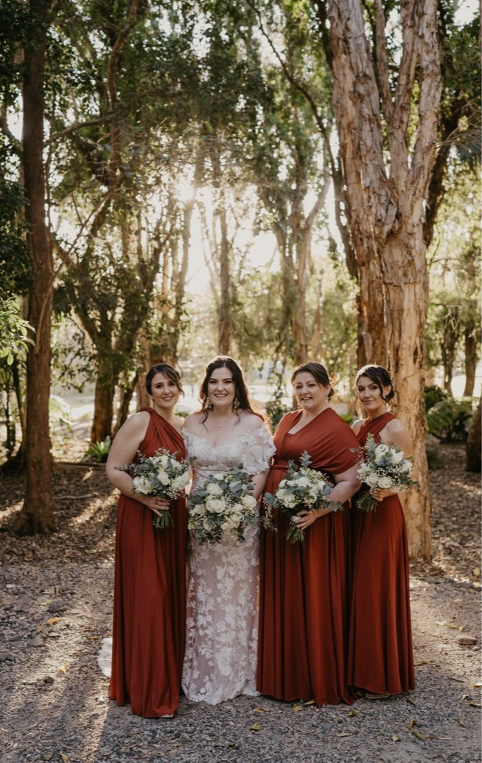 Bride and three bridesmaids in forest wearing Copper Infinity Gown, a convertible dress