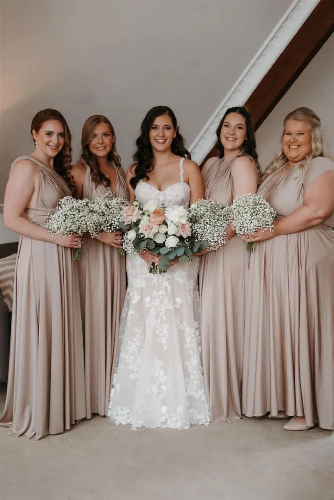Bride in white lace gown with four beige bridesmaid dresses holding bouquets, infinity gown style